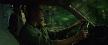 Movie still from “Gone Girl” (2014), directed by David Fincher – A woman sitting in the drivers seat of a car at night; Medium shot, Low angle