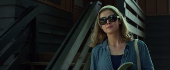 Movie still from “Gone Girl” (2014), directed by David Fincher – A woman wearing sunglasses standing next to a staircase; Close Up shot, Low angle