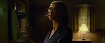 Movie still from “Gone Girl” (2014), directed by David Fincher – A woman is smoking a cigarette while wearing glasses; Close Up shot, Low angle