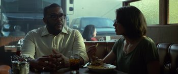 Movie still from “Gone Girl” (2014), directed by David Fincher – A man and a woman sitting at a table with a plate of food in front of them; Medium shot, Over the shoulder angle