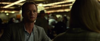 Movie still from “Gone Girl” (2014), directed by David Fincher – A man in a gray suit is looking at the camera; Close Up shot, Over the shoulder angle