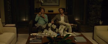 Movie still from “Gone Girl” (2014), directed by David Fincher – A man and a woman sitting on a couch in a living room; Medium shot, High angle