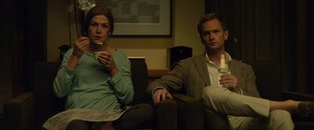 Movie still from “Gone Girl” (2014), directed by David Fincher – A man and a woman are sitting on a couch; Medium shot, High angle