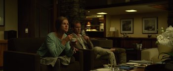 Movie still from “Gone Girl” (2014), directed by David Fincher – A man and a woman sitting on a couch drinking wine; Medium shot, Over the shoulder angle