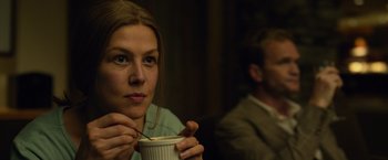 Movie still from “Gone Girl” (2014), directed by David Fincher – A woman sitting at a table with a cup of coffee; Close Up shot, Over the shoulder angle
