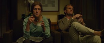 Movie still from “Gone Girl” (2014), directed by David Fincher – A woman and a man sitting on a couch; Medium shot, Over the shoulder angle