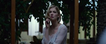 Movie still from “Gone Girl” (2014), directed by David Fincher – A woman in a white shirt is talking on a cell phone; Close Up shot, Low angle