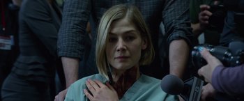 Movie still from “Gone Girl” (2014), directed by David Fincher – A woman with a neck injury is sitting in a room; Close Up shot, Over the shoulder angle