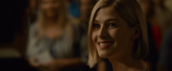 Movie still from “Gone Girl” (2014), directed by David Fincher – A person with blonde hair smiling; Close Up shot, Over the shoulder angle