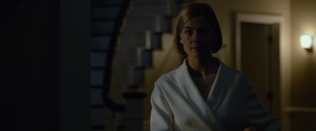 Movie still from “Gone Girl” (2014), directed by David Fincher – A woman in a white robe standing in a dark room; Medium shot, Low angle