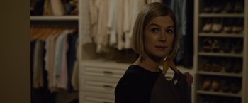 Movie still from “Gone Girl” (2014), directed by David Fincher – A woman in a black shirt is holding a brown bag; Close Up shot, Over the shoulder angle