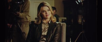 Movie still from “Gone Girl” (2014), directed by David Fincher – A woman sitting in a chair wearing a leather jacket; Medium shot, Over the shoulder angle