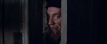 Movie still from “The Fearless Vampire Killers” (1967), directed by Roman Polanski – A man with a beard and a hat smoking a cigarette; Close Up shot, Low angle