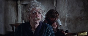 Movie still from “The Fearless Vampire Killers” (1967), directed by Roman Polanski – An old man with a white beard and a young man drinking from a cup; Close Up shot, Over the shoulder angle
