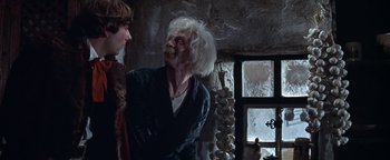 Movie still from “The Fearless Vampire Killers” (1967), directed by Roman Polanski – Two people in a room with a stone wall; Medium shot, Low angle