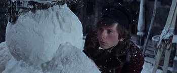 Movie still from “The Fearless Vampire Killers” (1967), directed by Roman Polanski – A young man in a fur coat and hat looking at a large piece of snow in front of him; Close Up shot, Low angle