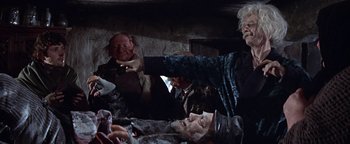 Movie still from “The Fearless Vampire Killers” (1967), directed by Roman Polanski – A group of people standing around a table; Medium shot, Over the shoulder angle