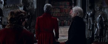 Movie still from “The Fearless Vampire Killers” (1967), directed by Roman Polanski – Two people in a room with many books on the shelves; Medium shot, Over the shoulder angle