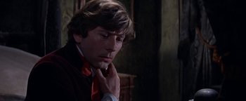 Movie still from “The Fearless Vampire Killers” (1967), directed by Roman Polanski – A man with long brown hair wearing a neck tie; Close Up shot, Over the shoulder angle