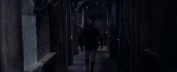 Movie still from “The Fearless Vampire Killers” (1967), directed by Roman Polanski – A person walking down a hallway in a dark room; Wide shot, High angle