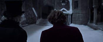 Movie still from “The Fearless Vampire Killers” (1967), directed by Roman Polanski – A woman in a red jacket is looking at a staircase; Medium shot, Over the shoulder angle