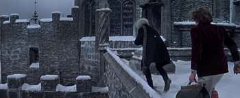 Movie still from “The Fearless Vampire Killers” (1967), directed by Roman Polanski – A person walking on a snow - covered stone wall; Wide shot, Low angle