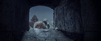 Movie still from “The Fearless Vampire Killers” (1967), directed by Roman Polanski – A person with a white beard looking through a hole in a wall; Wide shot, Low angle