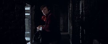 Movie still from “The Fearless Vampire Killers” (1967), directed by Roman Polanski – A man in a red jacket holding a black bag; Medium shot, Low angle