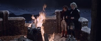 Movie still from “The Fearless Vampire Killers” (1967), directed by Roman Polanski – A group of people standing next to a fire; Wide shot, High angle