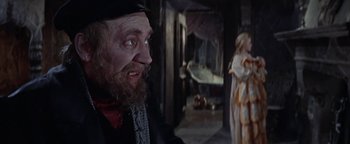 Movie still from “The Fearless Vampire Killers” (1967), directed by Roman Polanski – A man with a long beard and a hat is looking at a woman in a dress; Medium shot, Over the shoulder angle