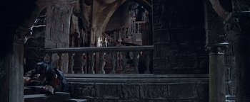 Movie still from “The Fearless Vampire Killers” (1967), directed by Roman Polanski – A dark room with a stone wall and a staircase; Wide shot, High angle
