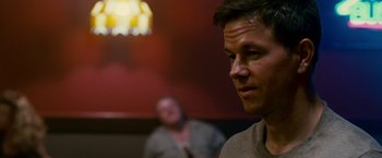 Movie still from “The Fighter” (2010), directed by David O. Russell – A person with a woman in the background; Close Up shot, Over the shoulder angle