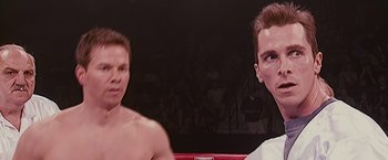 Two young men are standing in a boxing ring
