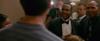 Movie still from “The Fighter” (2010), directed by David O. Russell – A man taking a picture of another man in a tuxedo; Close Up shot, Over the shoulder angle