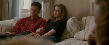 Movie still from “The Fighter” (2010), directed by David O. Russell – A man and a woman sitting next to each other on a couch; Medium shot, High angle