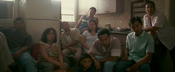 Movie still from “The Fighter” (2010), directed by David O. Russell – A group of people sitting on a couch in a room; Medium shot, High angle