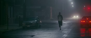 Movie still from “The Fighter” (2010), directed by David O. Russell – A man is running in the dark on a street; Wide shot, Low angle