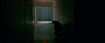 Movie still from “The Fighter” (2010), directed by David O. Russell – A man kneeling down in a dark hallway; Wide shot, High angle