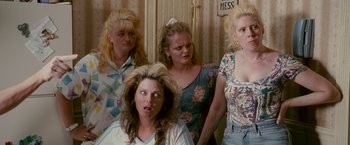 Movie still from “The Fighter” (2010), directed by David O. Russell – A group of women standing next to each other in a room; Medium shot, High angle