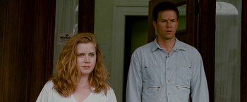 Movie still from “The Fighter” (2010), directed by David O. Russell – A man and a woman standing next to each other in front of a door; Medium shot, Low angle
