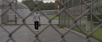 Movie still from “The Fighter” (2010), directed by David O. Russell – A man holding a catchers mitt walking across a field; Wide shot, Low angle