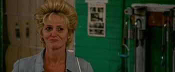 Movie still from “The Fighter” (2010), directed by David O. Russell – A woman with blonde hair is standing in front of a green wall; Close Up shot, Low angle