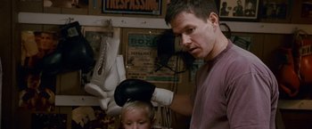Movie still from “The Fighter” (2010), directed by David O. Russell – A man and a boy are boxing in a room; Medium shot, Over the shoulder angle