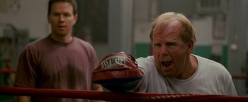 Movie still from “The Fighter” (2010), directed by David O. Russell – An older man holding a boxing glove in a ring; Close Up shot, Low angle