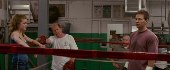 Movie still from “The Fighter” (2010), directed by David O. Russell – A man in a boxing ring holding a glove; Medium shot, Over the shoulder angle