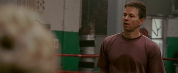 Movie still from “The Fighter” (2010), directed by David O. Russell – A man standing in front of a boxing ring; Medium shot, Over the shoulder angle