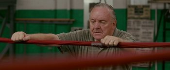 Movie still from “The Fighter” (2010), directed by David O. Russell – An older man holding onto a red bar; Close Up shot, Low angle