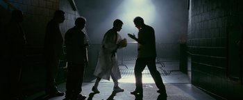 Movie still from “The Fighter” (2010), directed by David O. Russell – Two men are boxing in a dark room; Wide shot, Low angle