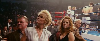 Movie still from “The Fighter” (2010), directed by David O. Russell – Two women in a boxing ring watching a fight; Medium shot, Over the shoulder angle