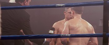Movie still from “The Fighter” (2010), directed by David O. Russell – Two men in a boxing ring with a referee behind them; Close Up shot, Over the shoulder angle